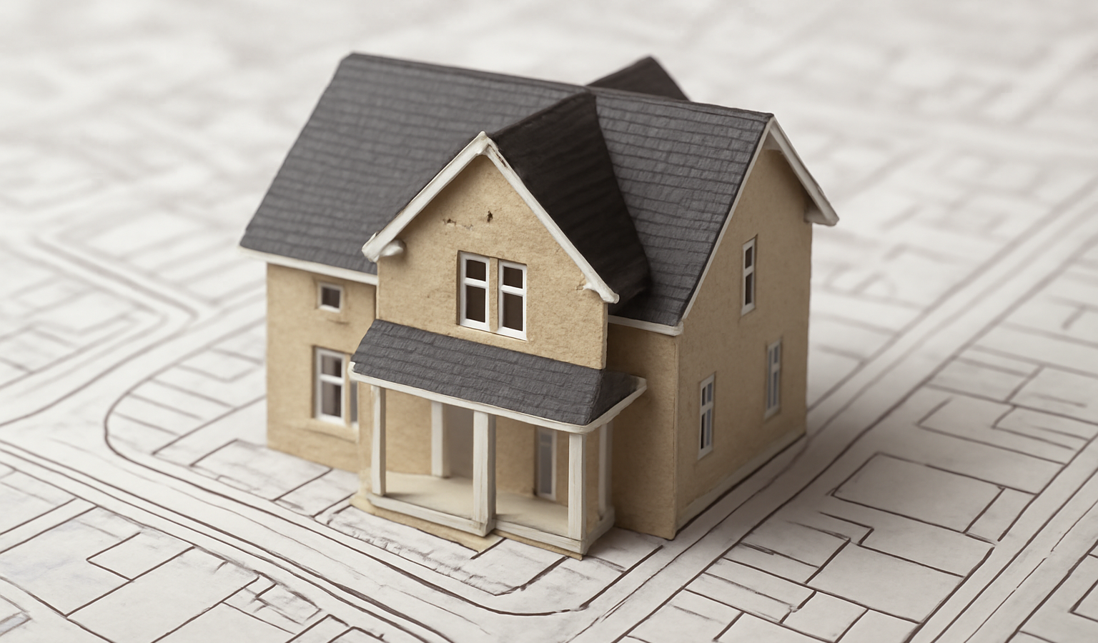 maquette de maison posée sur plan de ville